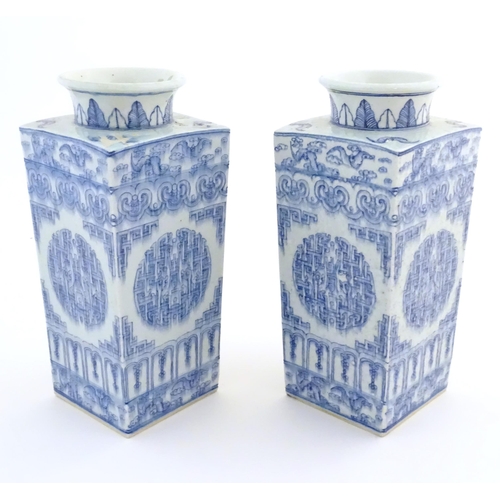 55 - A matched pair of Chinese blue and white Cong shaped vases, with a tall square tapering body with fl... 