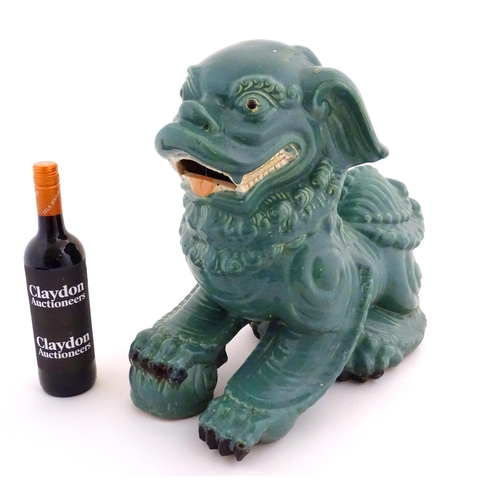 71 - An Oriental model of a guardian lion with a turquoise glaze. Approx. 16