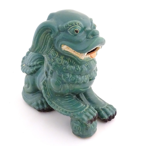 71 - An Oriental model of a guardian lion with a turquoise glaze. Approx. 16