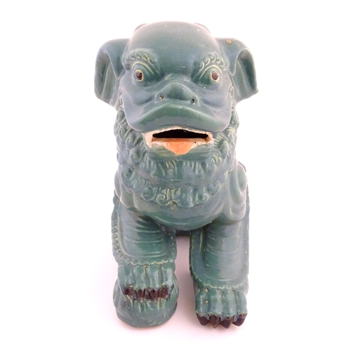 71 - An Oriental model of a guardian lion with a turquoise glaze. Approx. 16