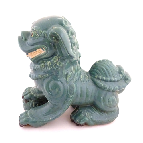 71 - An Oriental model of a guardian lion with a turquoise glaze. Approx. 16