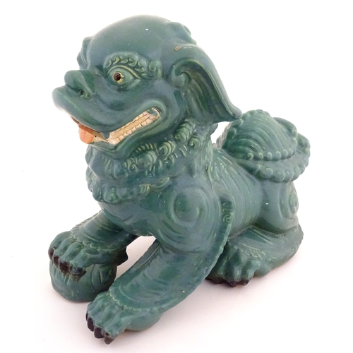 71 - An Oriental model of a guardian lion with a turquoise glaze. Approx. 16