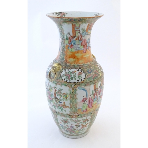 72 - A Chinese famille rose vase with a flared rim and twin ring mask handles in relief, decorated with f... 