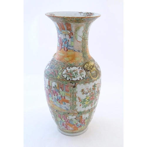 72 - A Chinese famille rose vase with a flared rim and twin ring mask handles in relief, decorated with f... 