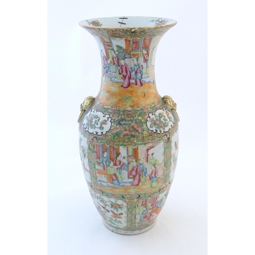 72 - A Chinese famille rose vase with a flared rim and twin ring mask handles in relief, decorated with f... 