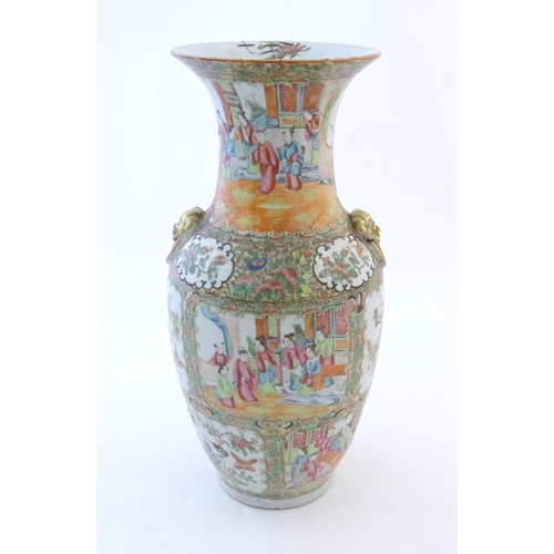 72 - A Chinese famille rose vase with a flared rim and twin ring mask handles in relief, decorated with f... 