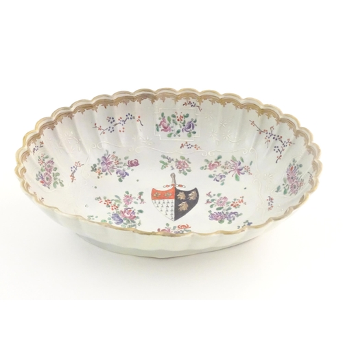 76 - A Chinese export bowl of oval form with scalloped edge, decorated with flowers, foliage and armorial... 