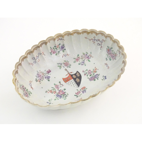 76 - A Chinese export bowl of oval form with scalloped edge, decorated with flowers, foliage and armorial... 