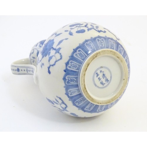 24 - An Oriental blue and white double gourd vase with twin handles decorated with scrolling floral and f... 