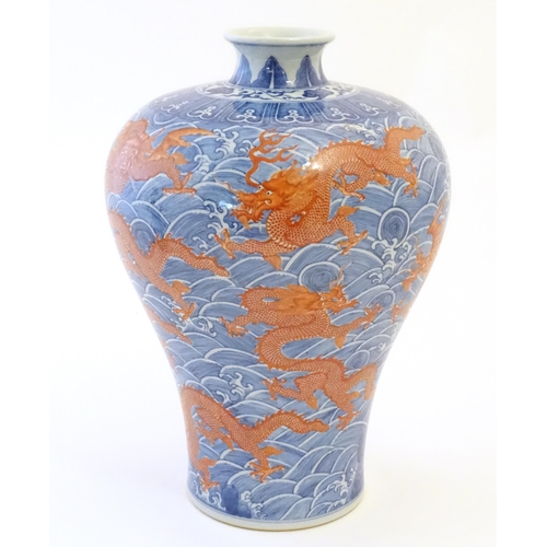 1 - A Chinese Meiping style vase decorated with red dragons amongst stylised waves. Character marks unde... 