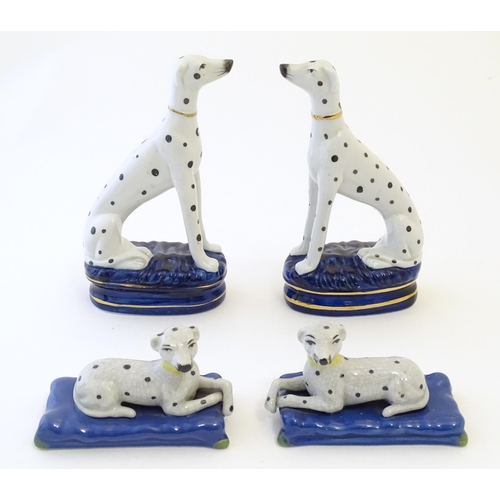 107 - A pair of Staffordshire pottery models of seated Dalmatians dogs on oval bases, together with a pair... 