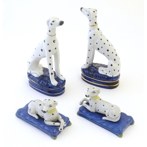 107 - A pair of Staffordshire pottery models of seated Dalmatians dogs on oval bases, together with a pair... 