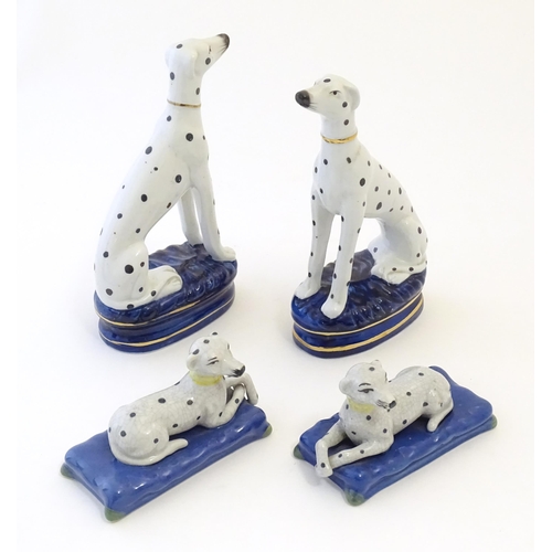 107 - A pair of Staffordshire pottery models of seated Dalmatians dogs on oval bases, together with a pair... 