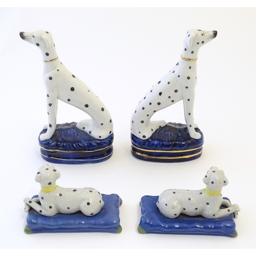 107 - A pair of Staffordshire pottery models of seated Dalmatians dogs on oval bases, together with a pair... 