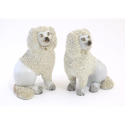 109 - A pair of Staffordshire pottery models of seated Poodle dogs with gilded collars. Approx. 5 1/2