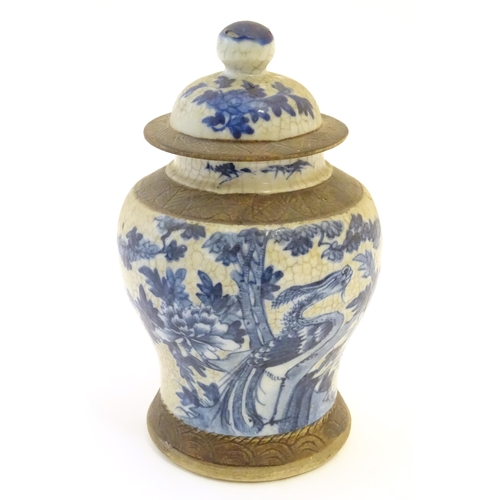 14 - A Chinese blue and white ginger jar with a crackle glaze, the body decorated with a bird in a tree, ... 