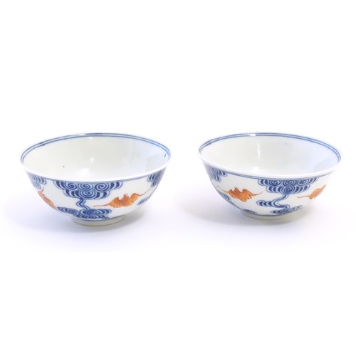26 - A pair of Chinese bowls decorated with stylised bats amongst clouds. Character marks under. Approx. ... 
