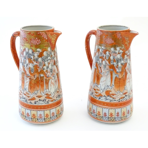 84 - A pair of Japanese Kutani jugs decorated with a crowd of scholars. Character marks under. Approx. 10... 