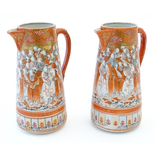 84 - A pair of Japanese Kutani jugs decorated with a crowd of scholars. Character marks under. Approx. 10... 