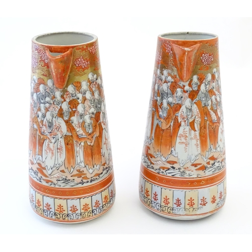 84 - A pair of Japanese Kutani jugs decorated with a crowd of scholars. Character marks under. Approx. 10... 