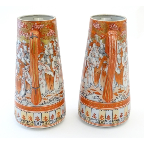 84 - A pair of Japanese Kutani jugs decorated with a crowd of scholars. Character marks under. Approx. 10... 