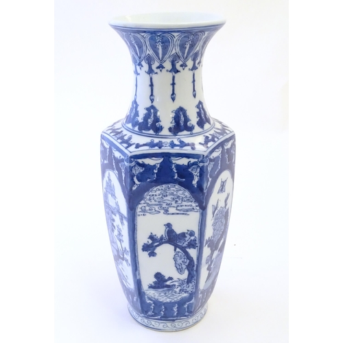 81 - An Oriental blue and white vase with panelled decoration depicting landscapes, birds perched on bran... 