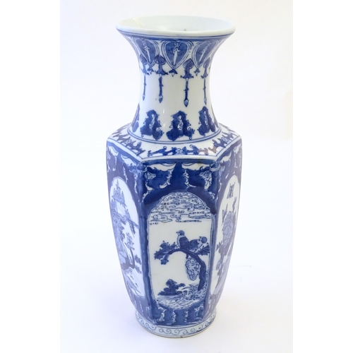 81 - An Oriental blue and white vase with panelled decoration depicting landscapes, birds perched on bran... 