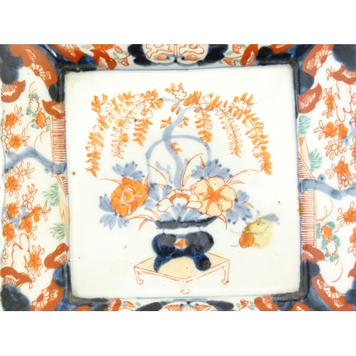 13 - A pair of Japanese plates of square form decorated in the Imari palette with a vase of flowers and f... 