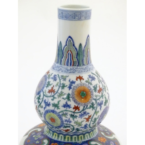 4 - A Chinese double gourd vase with doucai style decoration with scrolling floral and foliate detail. C... 