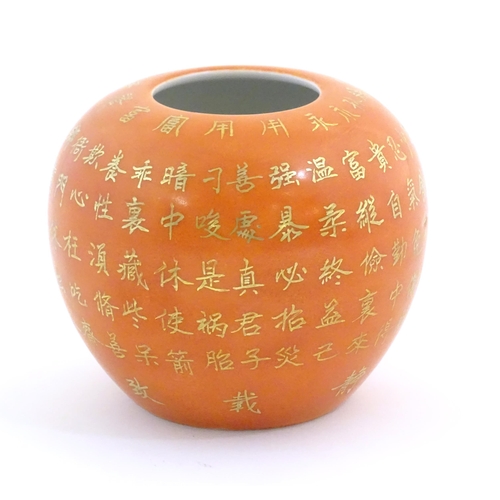 10 - A small Chinese vase of squat form with an orange ground and gilt character script decoration to bod... 