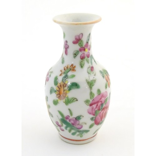 12 - A small Chinese famille rose baluster vase decorated with butterflies amongst flowers and foliage. A... 