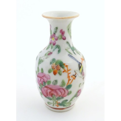 12 - A small Chinese famille rose baluster vase decorated with butterflies amongst flowers and foliage. A... 