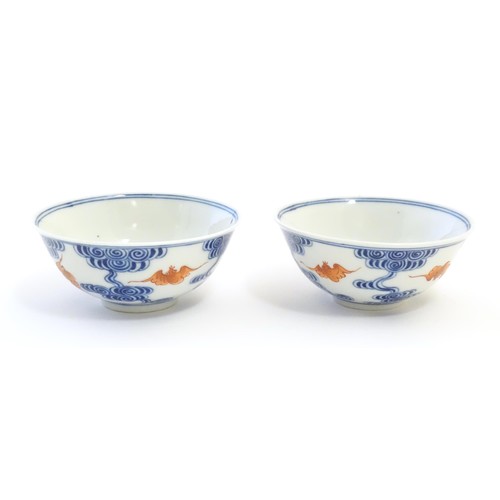 32 - A pair of Chinese bowls decorated with stylised bats amongst clouds. Character marks under. Approx. ... 