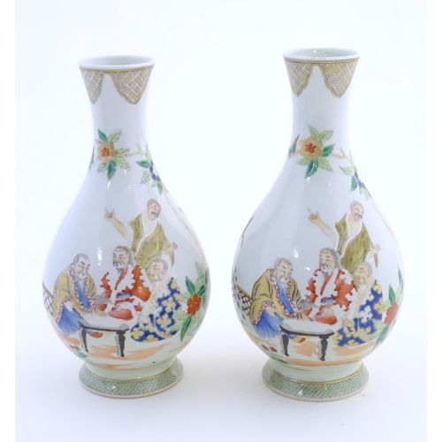 43 - A pair of Chinese famille rose bottle vases decorated with seated figures on a garden terrace, with ... 