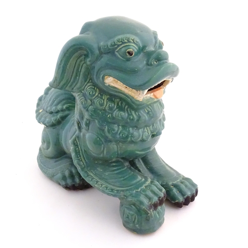 59 - An Oriental model of a guardian lion with a turquoise glaze. Approx. 16
