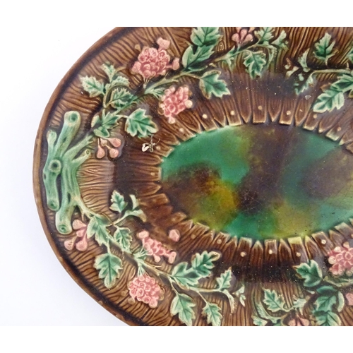 92 - A majolica oval serving dish in the manner of Wedgwood with floral decoration. Approx. 11 1/4