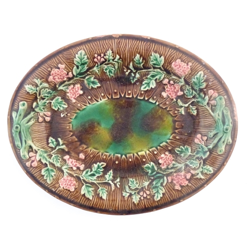 92 - A majolica oval serving dish in the manner of Wedgwood with floral decoration. Approx. 11 1/4