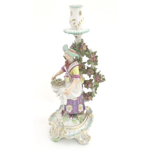 95 - A 19thC candlestick bocage figure, depicting a woman with a basket of flowers raised on a scrolling ... 