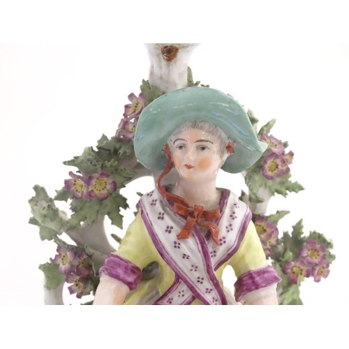 95 - A 19thC candlestick bocage figure, depicting a woman with a basket of flowers raised on a scrolling ... 