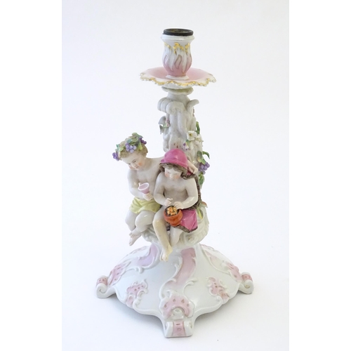 96 - A 20thC Continental figural candlestick with two cherubs on a scrolling base. Marked under. Approx. ... 