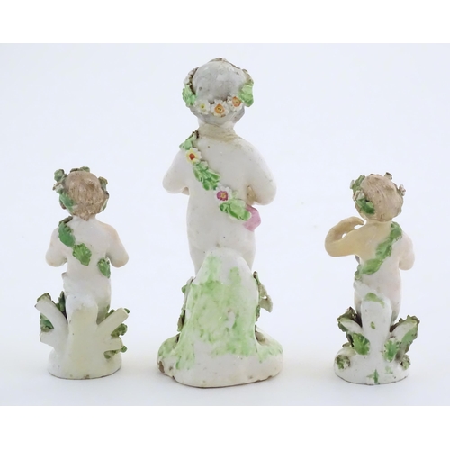 103 - Three Derby Porcelain style figures modelled as cherubs / young boys, two carrying baskets of flower... 