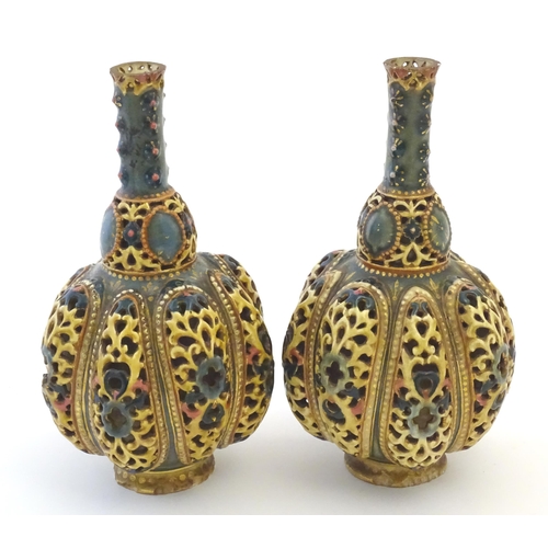 106 - A pair Zsolnay bottle vases with reticulated decoration. Indistinctly marked under. Approx. 8 1/4