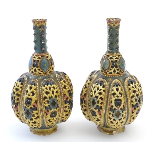 106 - A pair Zsolnay bottle vases with reticulated decoration. Indistinctly marked under. Approx. 8 1/4