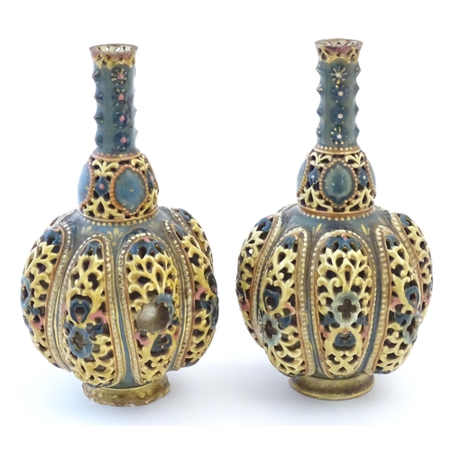 106 - A pair Zsolnay bottle vases with reticulated decoration. Indistinctly marked under. Approx. 8 1/4