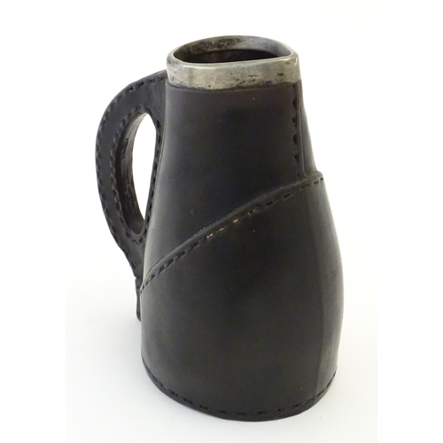 132 - A Victorian Doulton Lambeth pottery jug formed as a leather jack with a silver rim hallmarked London... 