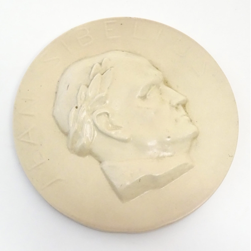 160 - A 20thC Arabia ceramic roundel / plaque depicting a portrait of the Finnish composer Jean Sibelius w... 