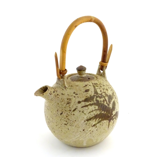 169 - A Continental studio pottery teapot with brushwork detail. Marked under. Approx. 13