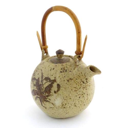 169 - A Continental studio pottery teapot with brushwork detail. Marked under. Approx. 13