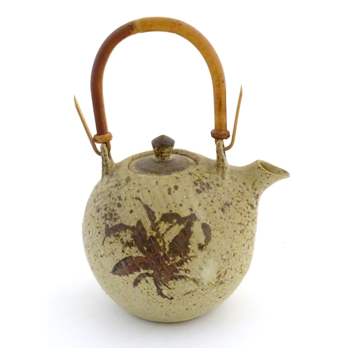 169 - A Continental studio pottery teapot with brushwork detail. Marked under. Approx. 13