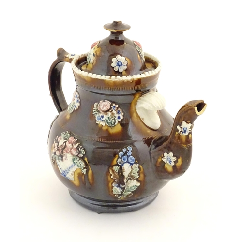 179 - A Victorian treacle glazed bargeware teapot with applied floral decoration and a banner for Mary Fen... 